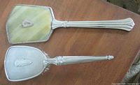 Hand mirror and hairbrush fronts showing handles and back of mirror