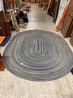Full view of oval braided rug on floor