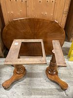 Entire table disassembled showing oval top, two pedestal bases, support frame pieces