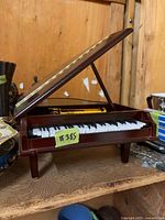 Miniature grand piano music box, lid open, showing keys and mechanism