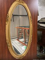 Front view of oval mirror showing gilt frame and glass