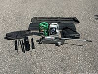 All items laid out: floor jack, scissor jacks, handles, pouches, two oil jugs, mats