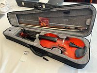 Violin inside case with bow and spare strings visible
