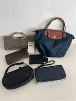 Group shot of all six bags and wallets