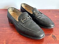 Three-quarter view of both loafers showing uppers, buckle detail, overall condition