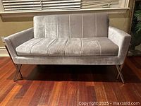 Front view of grey velvet loveseat with chrome base