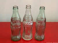 Front view of three Coca-Cola contour bottles