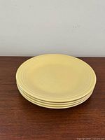 Stacked set of four yellow Fiesta plates side view