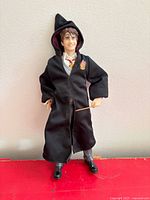 Full view of figure standing in robe holding wand