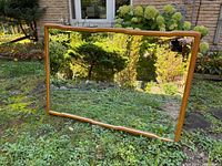 Full view of rectangular mirror with wood frame outdoors