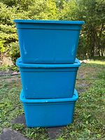 Front view of three stacked teal storage totes showing color and general condition