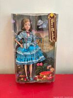 Front view of sealed box showing doll, Cheshire Cat, and themed graphics