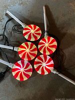 Five peppermint stake lights unlit showing stakes and wiring on floor