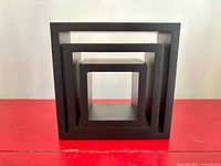 Front view showing nesting of three black square shelves