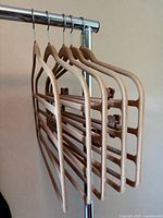 Five beige 4-bar velvet hangers on rail