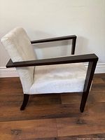 Side view showing wood arms, ivory upholstery