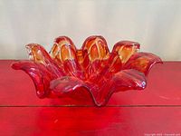 Oblique side view showing red-to-orange gradient and ruffled rim