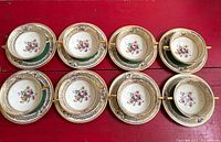 Eight complete bowl and saucer sets laid out