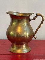 Front view of brass ewer showing body, spout and base
