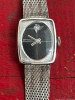 Front close-up of watch showing dial, bezel, mesh band