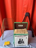 Lot overview showing green record case with 45s, brass rack, guitar stand