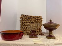 Group shot of all four items: De Silva bowl, glass compote, lidded container, fringed pillow