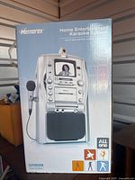 Front of boxed Memorex karaoke system showing unit image and microphone