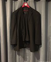 Full view of jacket, vest and pants on hanger