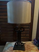 Full view of lamp with beige shade on table