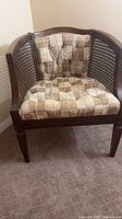Front view of barrel chair showing cushions and cane sides