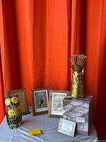 Group view of four wood frames, ceramic owl jar with lid, brass planter