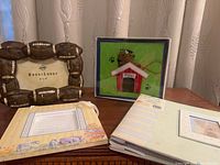 Group shot of all four items: football frame, doghouse frame, two baby photo albums