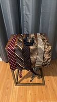 Overview of six ties draped on table with packaged YSL socks centred