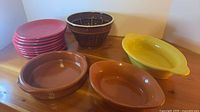 Group shot of dessert mold, eight red plates, three baking dishes