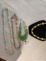 All four necklaces laid out on fabric