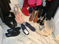 Grouped view of all nine pairs of boots and shoes on floor