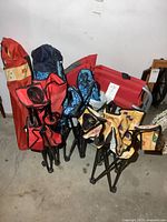 Group shot showing all folded chairs in bags, two open child chairs, and red chair with side table