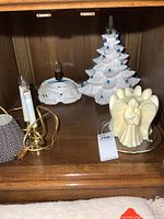 Overview showing tree, angel candle, two night lights and shade on shelf