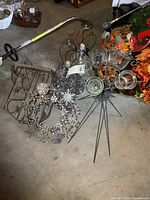 Assorted metal items including candle stand with glass cups, snowflake wreath, chrome lamps and log rack visible