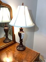 Full view of one lamp on dresser showing shade and base