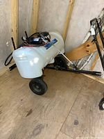 Full view of tow-behind sprayer showing tank, wheels and frame