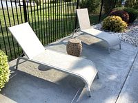 Both metal loungers and side table on patio