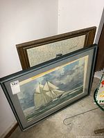 Both framed pieces leaning against wall