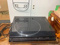 Front view of JVC AL-F350 turntable with dust cover closed and attached cables