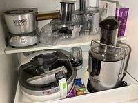Shelf with Veggie Bullet base, attachments, T-fal Actifry, Bullet cup, Juice Bullet and recipe books
