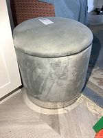 Full view of grey round microfiber ottoman