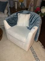 Front view of swivel tub chair with throw and cushion draped
