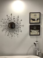 Mirror and two prints mounted on wall