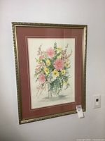 Framed floral watercolour hanging on wall showing full frame and mat