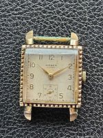 Front view showing dial, numerals, bezel, strap remnant